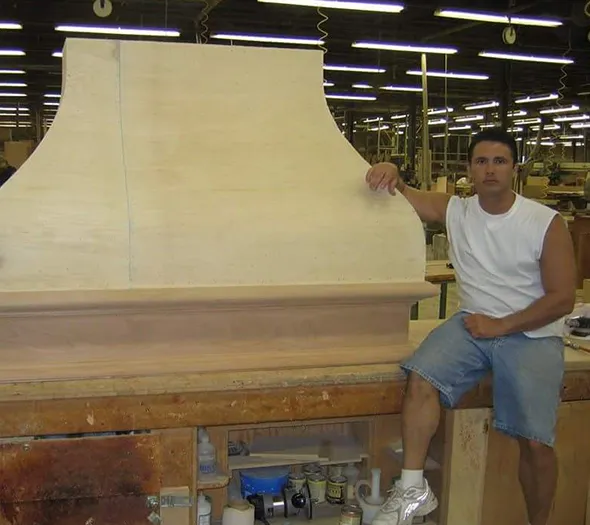 Man leaning on custom kitchen range hood crafted by Blue Springs handyman.